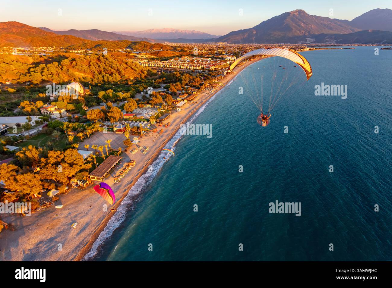 Luftaufnahme von Paramotoren, die in Formation am Calis Beach von Fethiye, Mugla, Türkei fliegen. Stockfoto