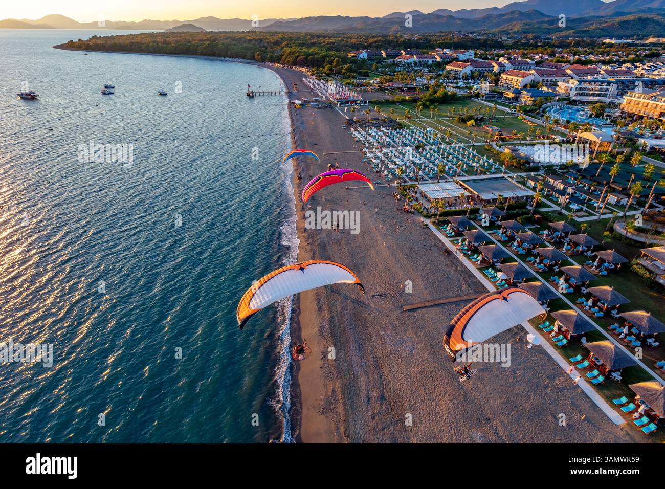 Luftaufnahme von Paramotoren, die in Formation am Calis Beach von Fethiye, Mugla, Türkei fliegen. Stockfoto