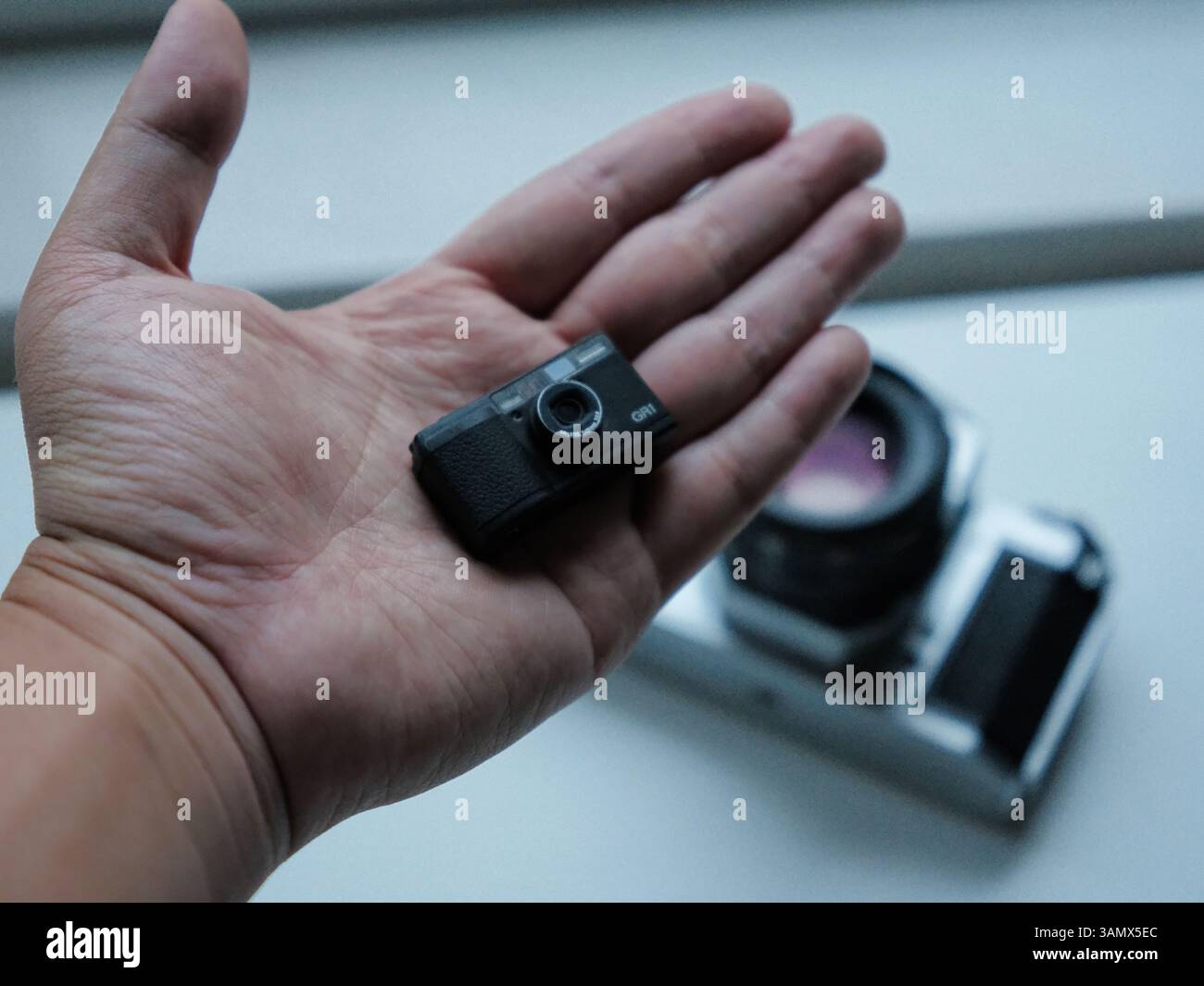 Moderne Nostalgie in einer Hand: Miniaturkamera, die die Mischung aus Tradition und digitaler Innovation der chinesischen Jugend widerspiegelt Stockfoto
