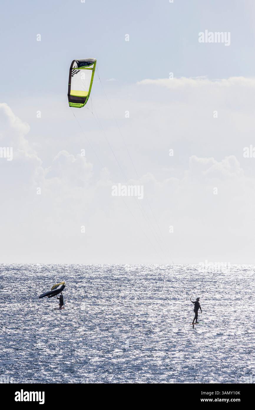 Windsurfen und Kitesurfen an einem hellen windigen Tag in El Medano an der Ostküste von Teneriffa, Kanarischen Inseln, Spanien Stockfoto