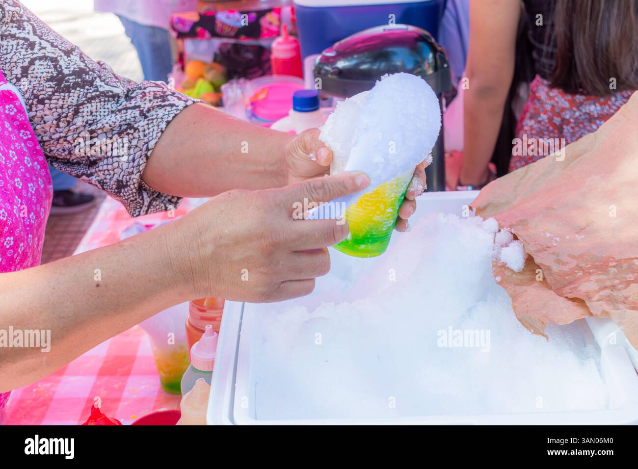 Nahaufnahme der Hände einer älteren Latina-Frau, die am Straßenstand ein Getränk mit Eis zubereitete Stockfoto