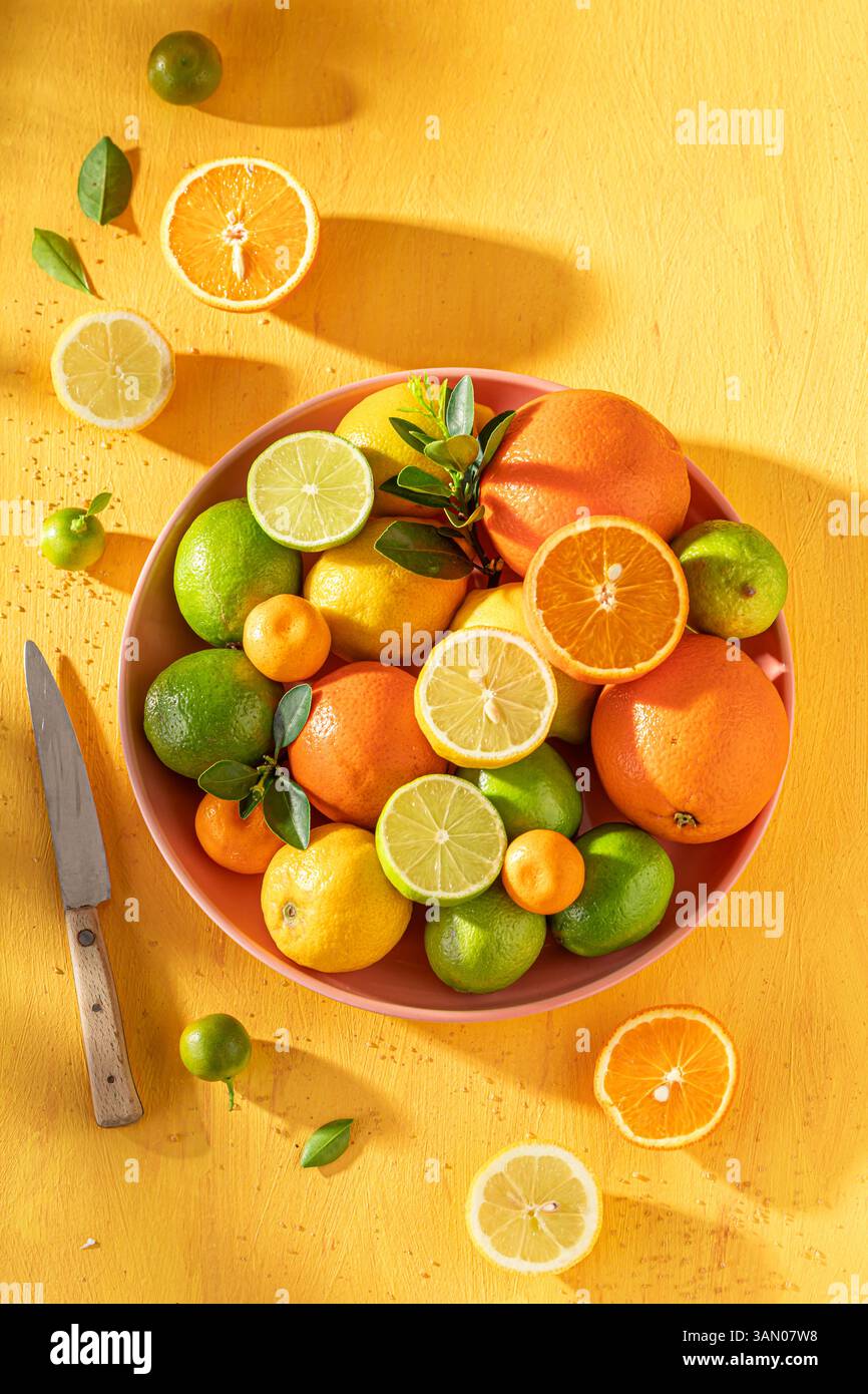 Gesunde Mischung von Zitrusfrüchten als Zutaten für Limonade. Mischung aus Zitrusfrüchten auf gelbem Tisch. Stockfoto