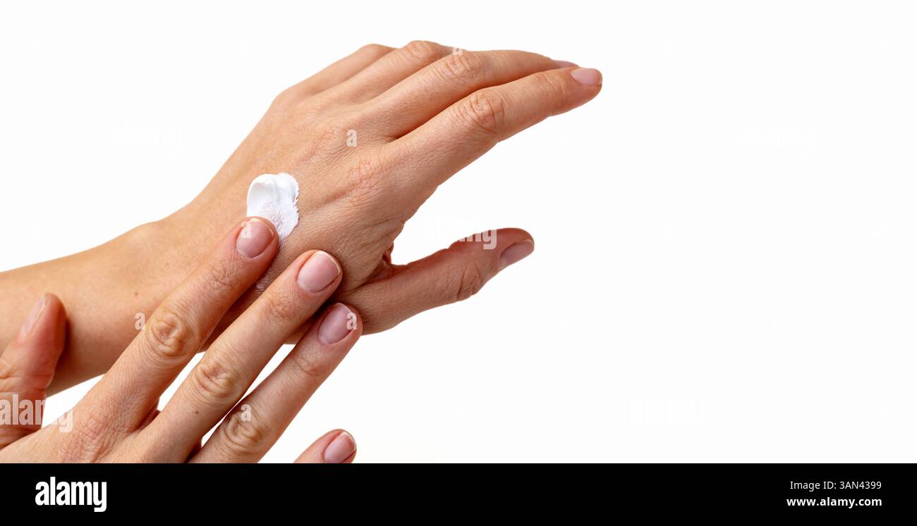 Nahaufnahme weiblicher Hände mit weißer Creme auf weißem Hintergrund Stockfoto