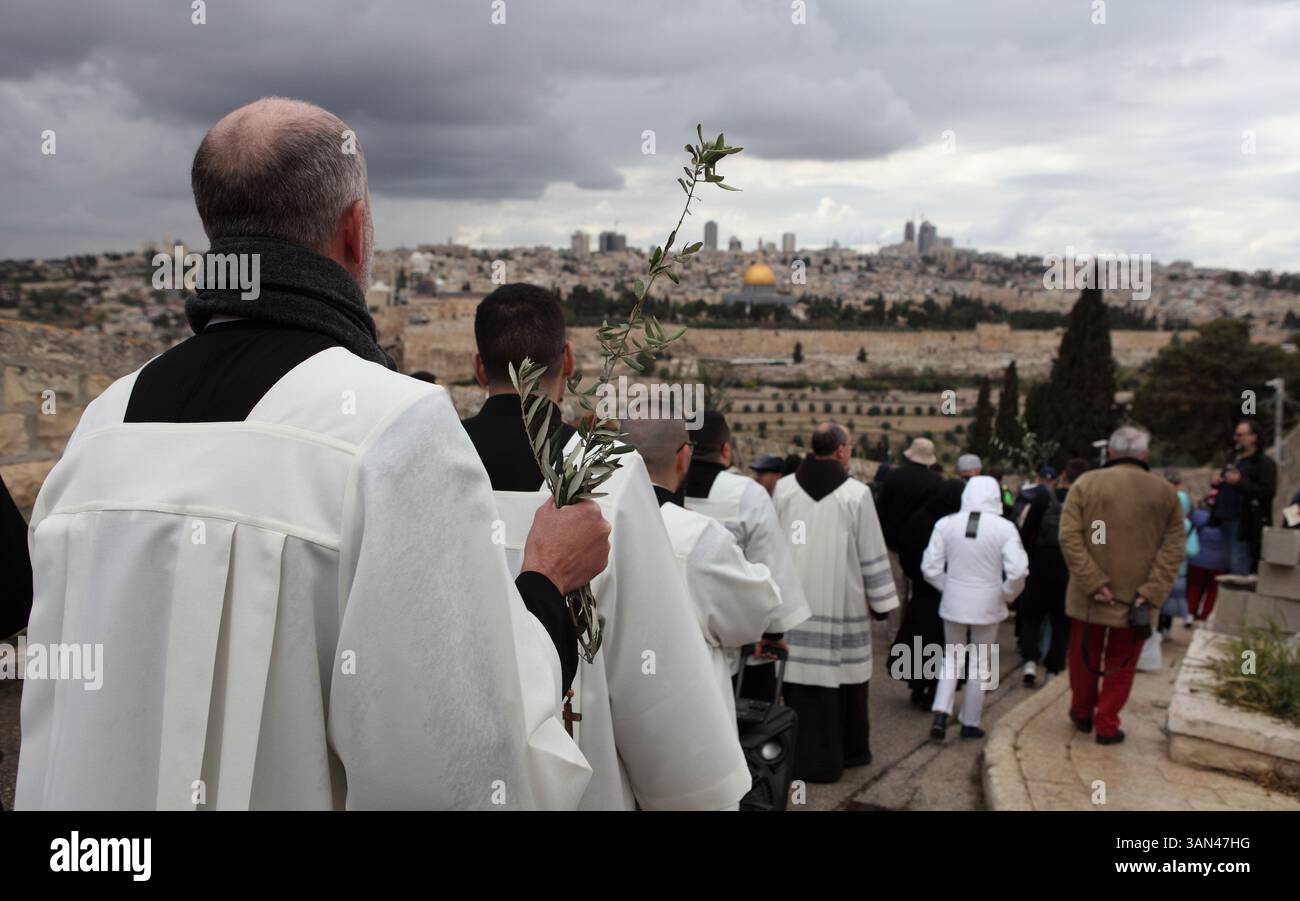 Christliche Pilger gehen vom Mt. Oliven in einer Palmensonntagsprozession mit Palmenwedel und Olivenbaumzweigen die Kuppel des Felsens gesehen. Stockfoto