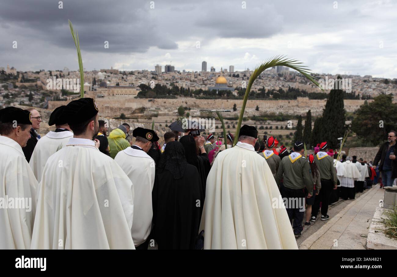 Christliche Pilger gehen vom Mt. Oliven in einer Palmensonntagsprozession mit Palmenwedel und Olivenbaumzweigen die Kuppel des Felsens gesehen. Stockfoto
