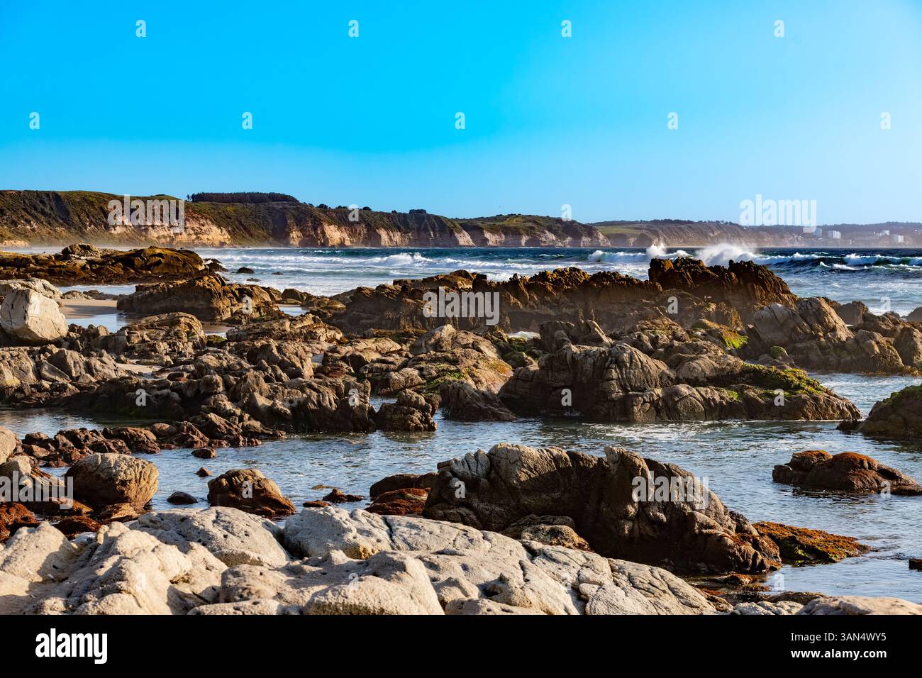 Wellen stürzen hinter den felsigen Stränden in der Stadt Maitencillo, mit Klippen im Hintergrund, Chile Stockfoto