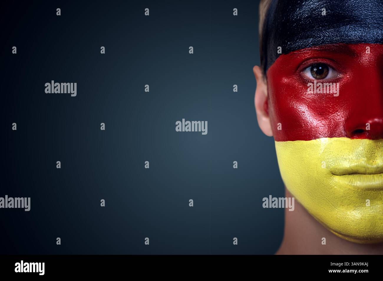 Fußballfan mit deutscher Flagge über das Gesicht. Ideal für Sportveranstaltungen und patriotische Themen. Stockfoto