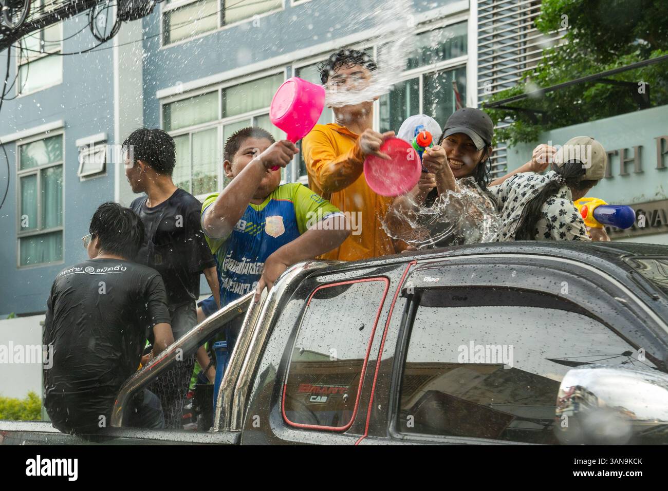 Bangkok, Thailand. April 2025. Eine Nahaufnahme von Kindern, die während des Songkran Festivals auf dem Huai Khwang Market Wasser werfen, während sie auf der offenen Rückseite eines Lastwagens stehen. Songkran, Thailands traditionelles Neujahrsfest, das ab April 13-15 stattfindet, ist eine der lebhaftesten und freudigsten Feierlichkeiten des Landes. Die Stadt ist vor allem für ihre massiven Wasserkämpfe auf den Straßen bekannt, die das Abwaschen von Unglück und Unglück symbolisieren und einen Neuanfang für das kommende Jahr darstellen. Quelle: SOPA Images Limited/Alamy Live News Stockfoto