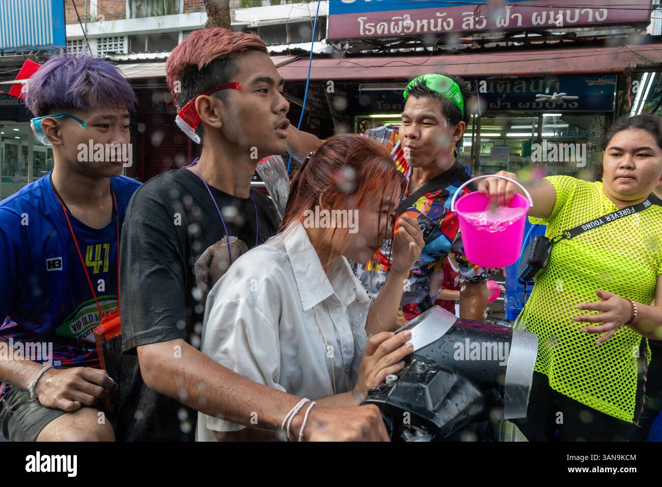 Bangkok, Thailand. April 2025. Eine Nahaufnahme von Menschen, die auf einem Motorrad sitzen und während des Songkran Festivals auf dem Huai Khwang Markt mit Wasser übergossen wurden. Songkran, Thailands traditionelles Neujahrsfest, das ab April 13-15 stattfindet, ist eine der lebhaftesten und freudigsten Feierlichkeiten des Landes. Die Stadt ist vor allem für ihre massiven Wasserkämpfe auf den Straßen bekannt, die das Abwaschen von Unglück und Unglück symbolisieren und einen Neuanfang für das kommende Jahr darstellen. Quelle: SOPA Images Limited/Alamy Live News Stockfoto