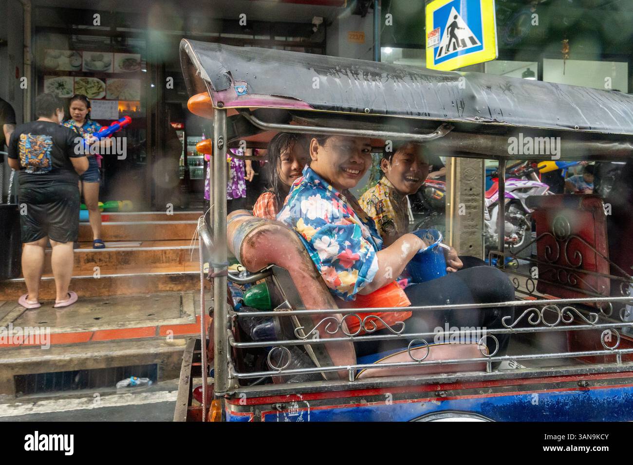 Bangkok, Thailand. April 2025. Eine Mutter und Kinder sitzen während des Songkran Festivals auf dem Huai Khwang Markt in einem Tuk-Tuk. Songkran, Thailands traditionelles Neujahrsfest, das ab April 13-15 stattfindet, ist eine der lebhaftesten und freudigsten Feierlichkeiten des Landes. Die Stadt ist vor allem für ihre massiven Wasserkämpfe auf den Straßen bekannt, die das Abwaschen von Unglück und Unglück symbolisieren und einen Neuanfang für das kommende Jahr darstellen. Quelle: SOPA Images Limited/Alamy Live News Stockfoto