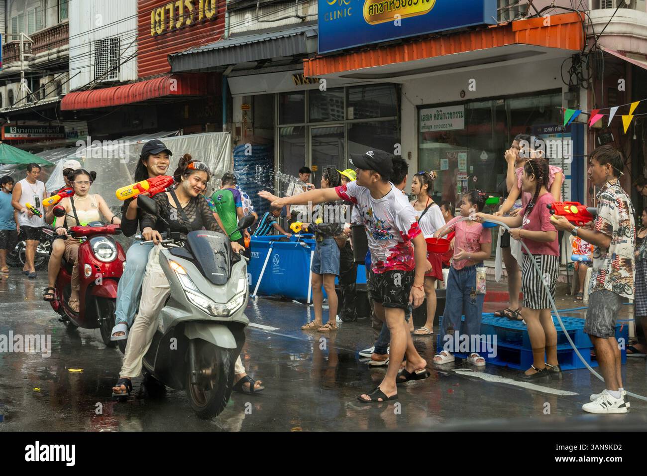 Bangkok, Thailand. April 2025. Während des Songkran Festivals auf dem Huai Khwang Market spritzen die Leute Wasser auf vorbeifahrende Motorräder. Songkran, Thailands traditionelles Neujahrsfest, das ab April 13-15 stattfindet, ist eine der lebhaftesten und freudigsten Feierlichkeiten des Landes. Die Stadt ist vor allem für ihre massiven Wasserkämpfe auf den Straßen bekannt, die das Abwaschen von Unglück und Unglück symbolisieren und einen Neuanfang für das kommende Jahr darstellen. Quelle: SOPA Images Limited/Alamy Live News Stockfoto