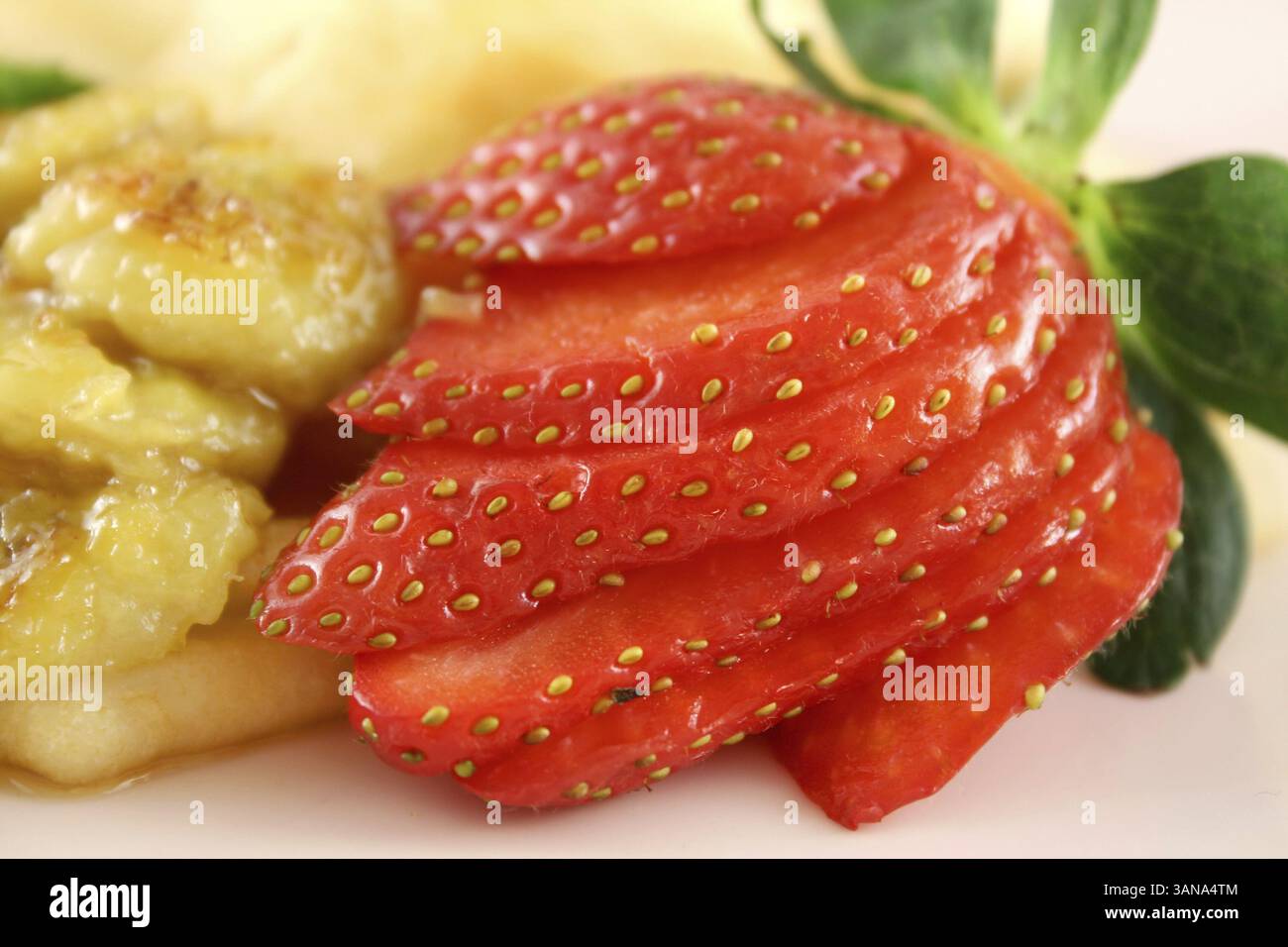 Karamellisierte Bananencrepes mit Erdbeeren, Kiwis und Butterscotch-Sauce Stockfoto