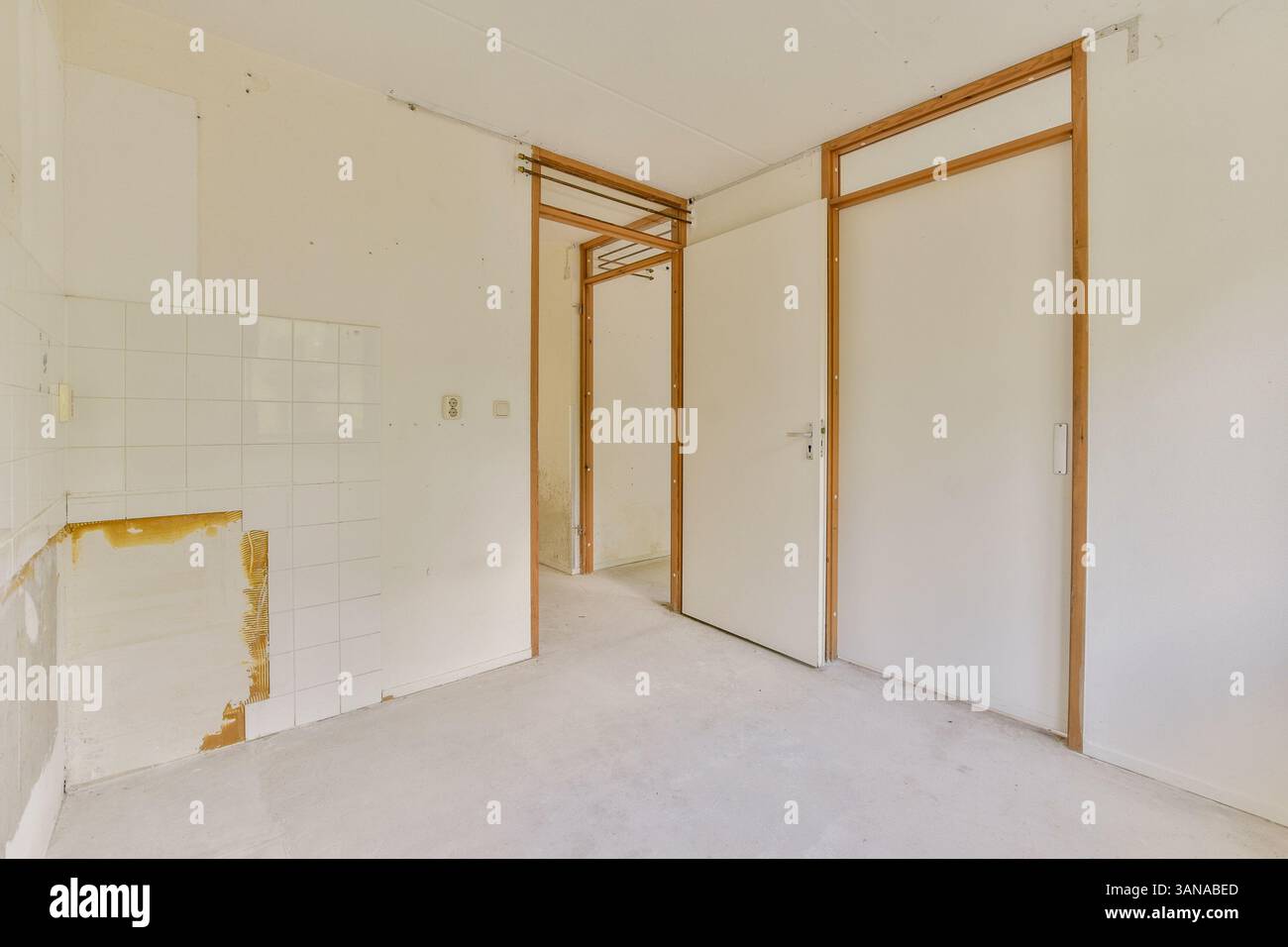 Ein leerer Raum mit moderner minimalistischer Architektur mit weißen Wänden und Holzakzenten. Perfekt für Inspirationen für Innenarchitektur oder Renovierungsideen. Stockfoto