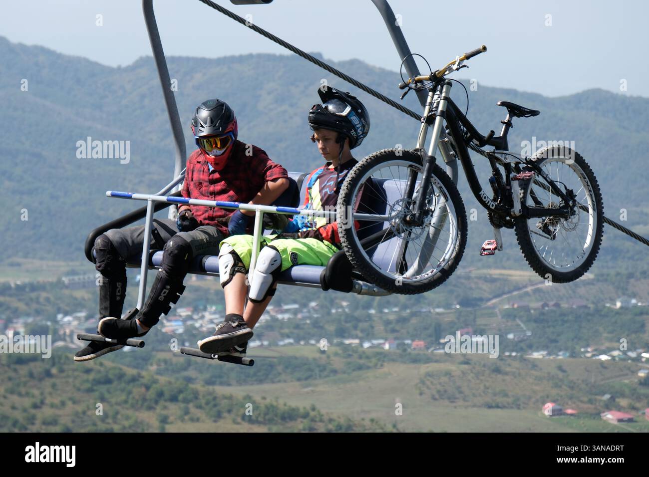 Seilbahn mit offenen Sitzen. Die Leute reiten über die Hügel zur Ruhestätte. Stockfoto