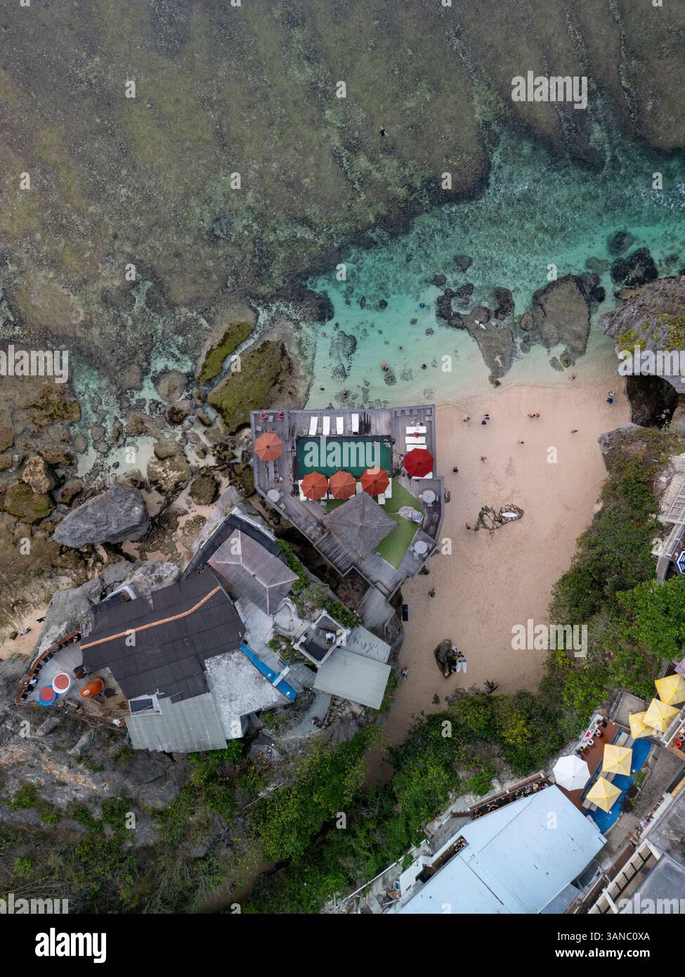 Aus der Vogelperspektive auf das wunderschöne türkisfarbene Meer und den Sandstrand mit dramatischen Klippen und Felsen, Uluwatu, Bali, Indonesien. Stockfoto