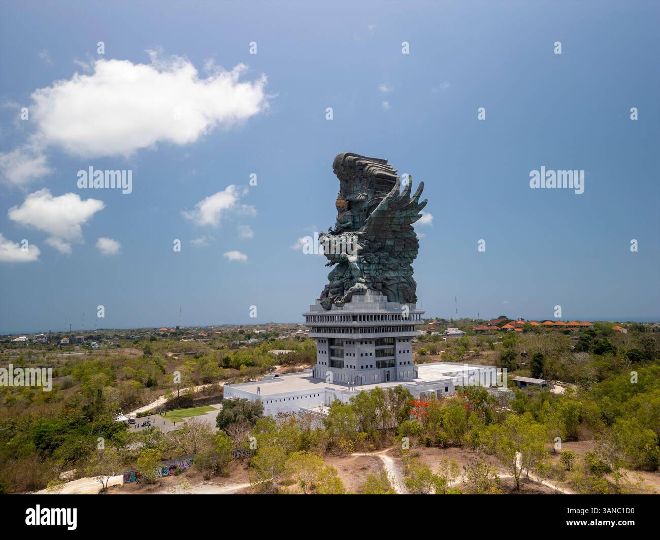 Blick aus der Vogelperspektive auf die berühmte Statue Patung Garuda Wisnu Kencana, umgeben von üppigem Grün und einem klaren blauen Himmel, Kuta Selatan, Indonesien. Stockfoto