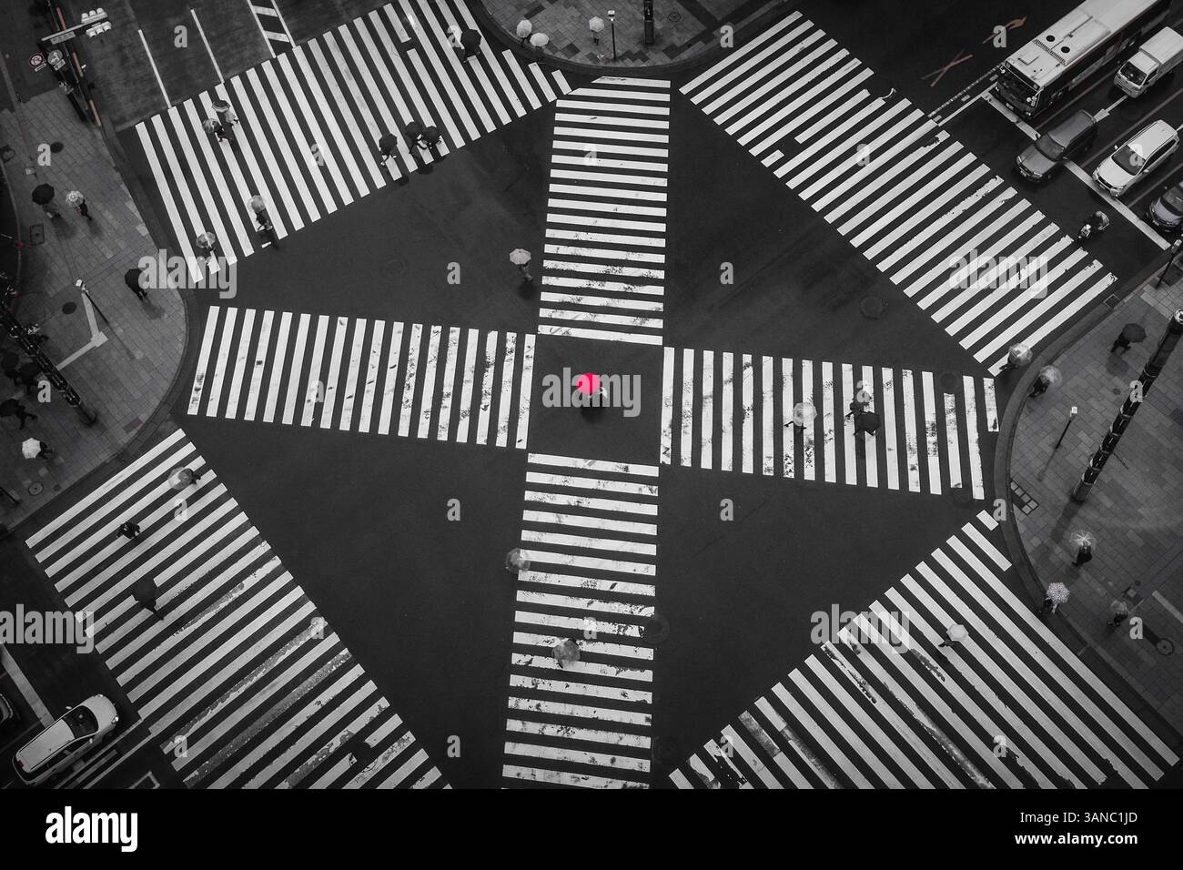 Roter Regenschirm an einem Kreuz in Tokio, regnerischer Tag Stockfoto