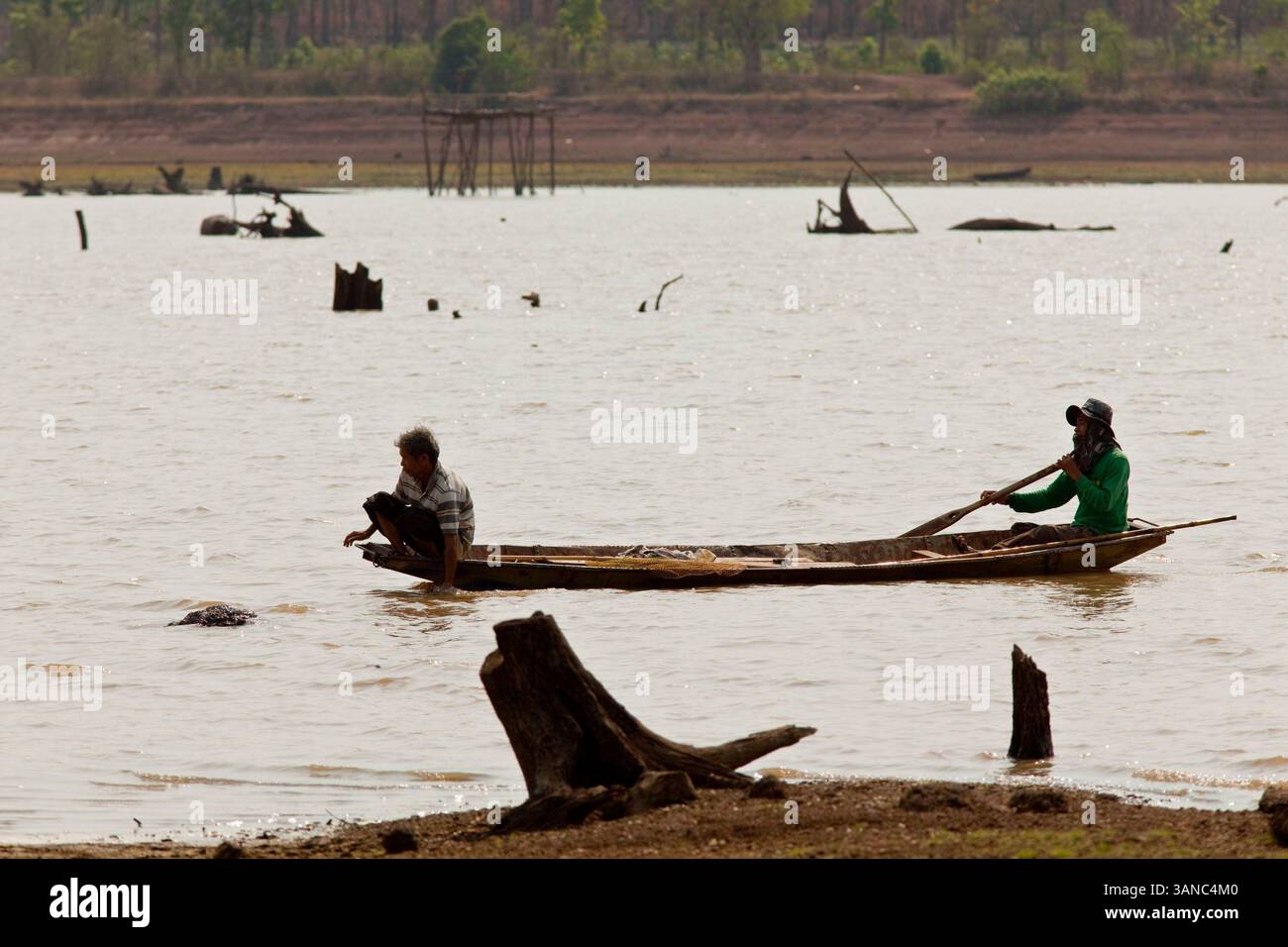 April 2010 - Nakhon Phanom, Thailand - die Menschen versuchen, im Boden des Hua hin Sanon Reservoir in der Provinz Nakhon Phanom, Thailand zu fischen. Das Reservoir ist so niedrig, dass die Baumstümpfe, die beim Öffnen zurückgelassen wurden, jetzt auftauchen. Das 600 Hektar große Reservoir wurde 1985 gebaut und ist im ersten Jahr leer. Die Region befindet sich inmitten einer rekordverdächtigen Dürre, und der Mekong ist an seinem tiefsten Punkt seit fast 50 Jahren und hat eine Umweltkatastrophe ausgelöst, die die Region noch nie erlebt hat. Viele der Menschen, die entlang der Flussfarm leben und fischen. Sie behaupten, dass ihre Ernteerträge stark rot sind Stockfoto