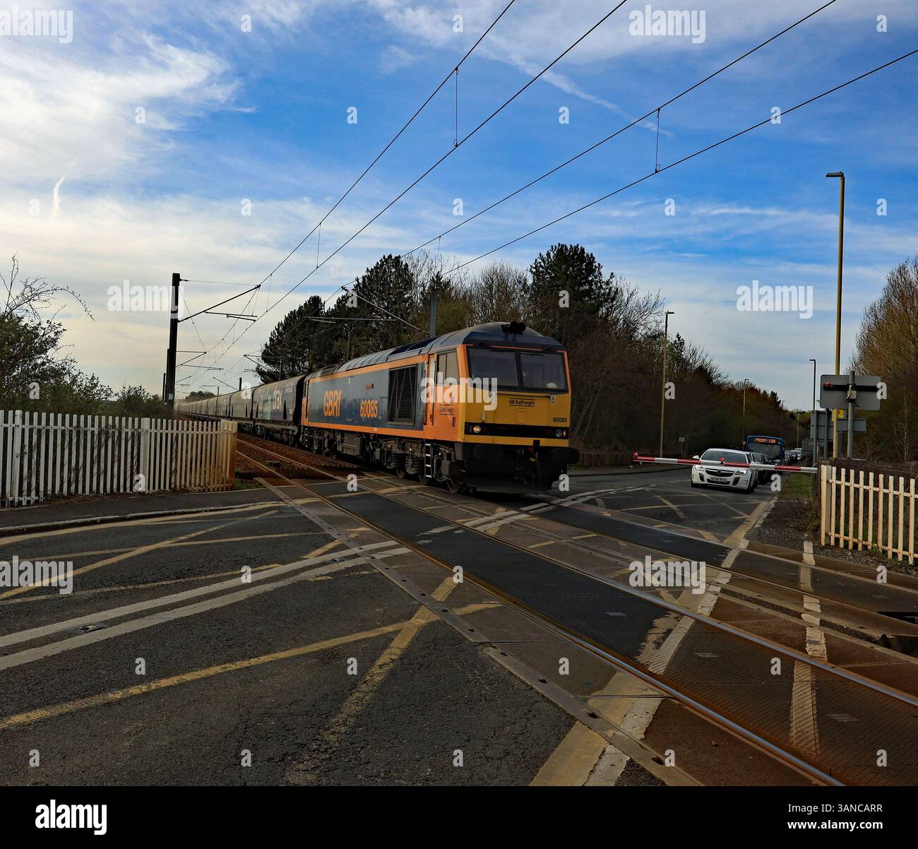 Die GBRf-Lokomotive Nr. 60085 überquert den Bahnübergang der Bolden Lane mit ihrem Zug importierter Biomasse als 16,54-Stunden-Verbindung zum Kraftwerk Drax. Stockfoto