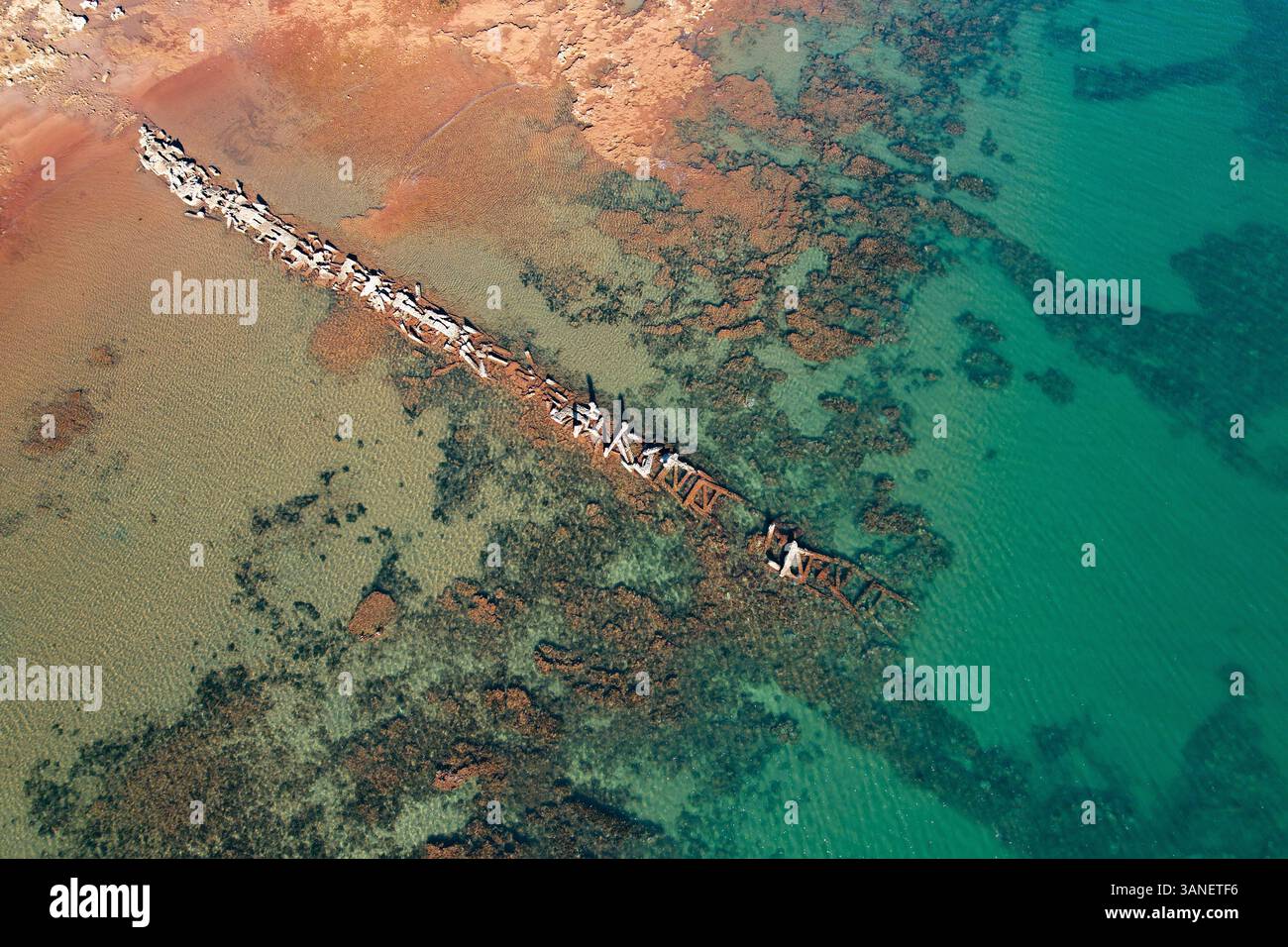 Blick aus der Vogelperspektive auf Beadon Bay bei Sonnenuntergang mit Onslow Old Salt Loading Steg und ruhiger Küste, Onslow, Australien. Stockfoto