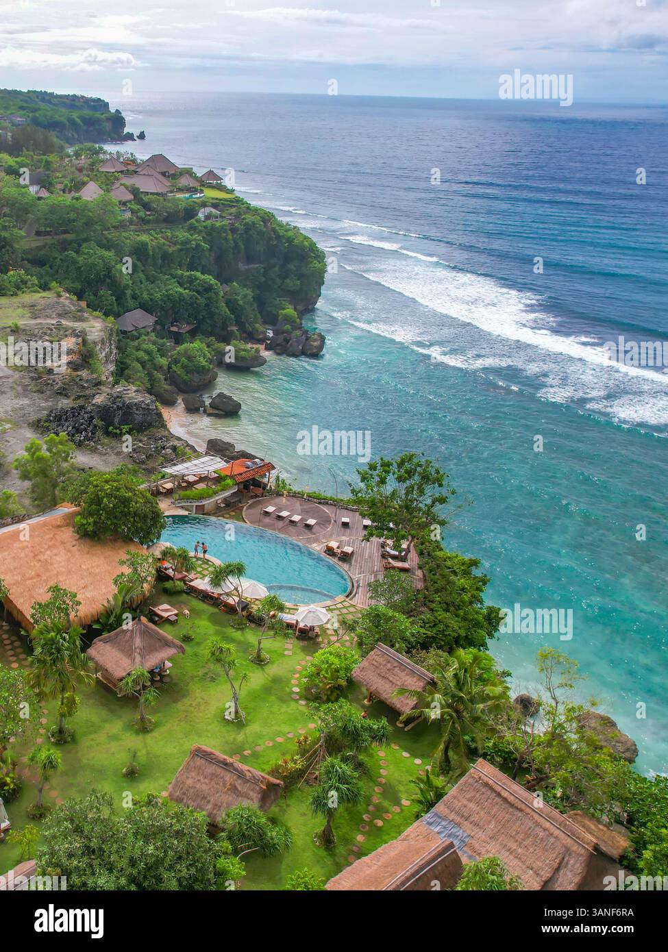 Blick aus der Vogelperspektive auf den Sandstrand mit blauen Meereswellen, Mu Boutique Hotel, Bali, Indonesien. Stockfoto