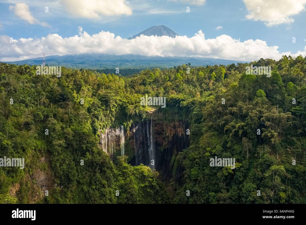 Luftaufnahme des Tumpak Sewu Wasserfalls in Java, Indonesien mit dem Vulkan Semeru im Hintergrund. Stockfoto