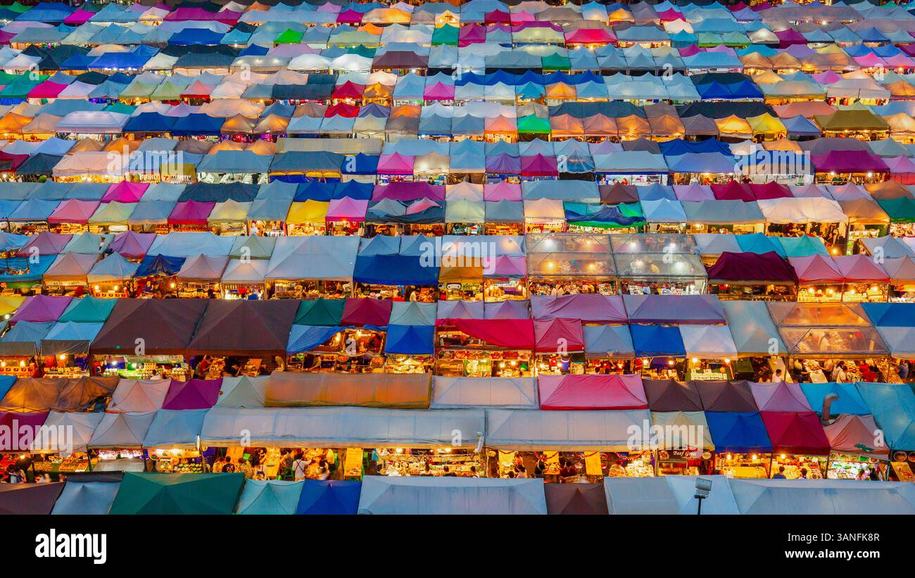 Blick aus der Vogelperspektive auf den lebhaften und geschäftigen Rod Fai Markt mit farbenfrohen Ständen und Zelten, Bangkok, Zentralthailand. Stockfoto
