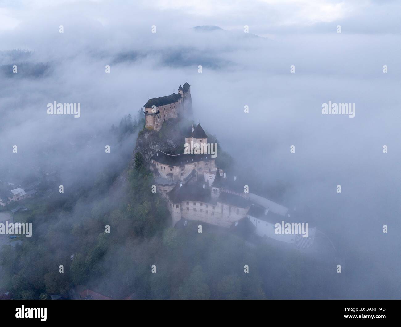 Aus der Vogelperspektive auf die Burg Orava im Nebel bei Sonnenaufgang, Oravsky Podzamok, Zilina, Slowakei. Stockfoto