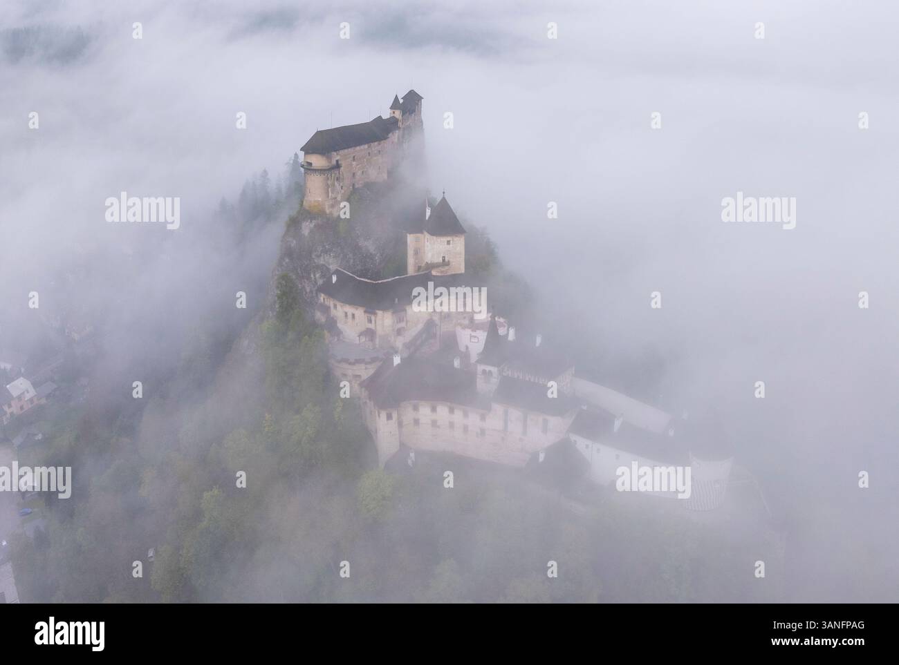 Aus der Vogelperspektive auf das Schloss Orava, umgeben von Nebel bei Sonnenaufgang, Oravsky Podzamok, Zilina, Slowakei. Stockfoto