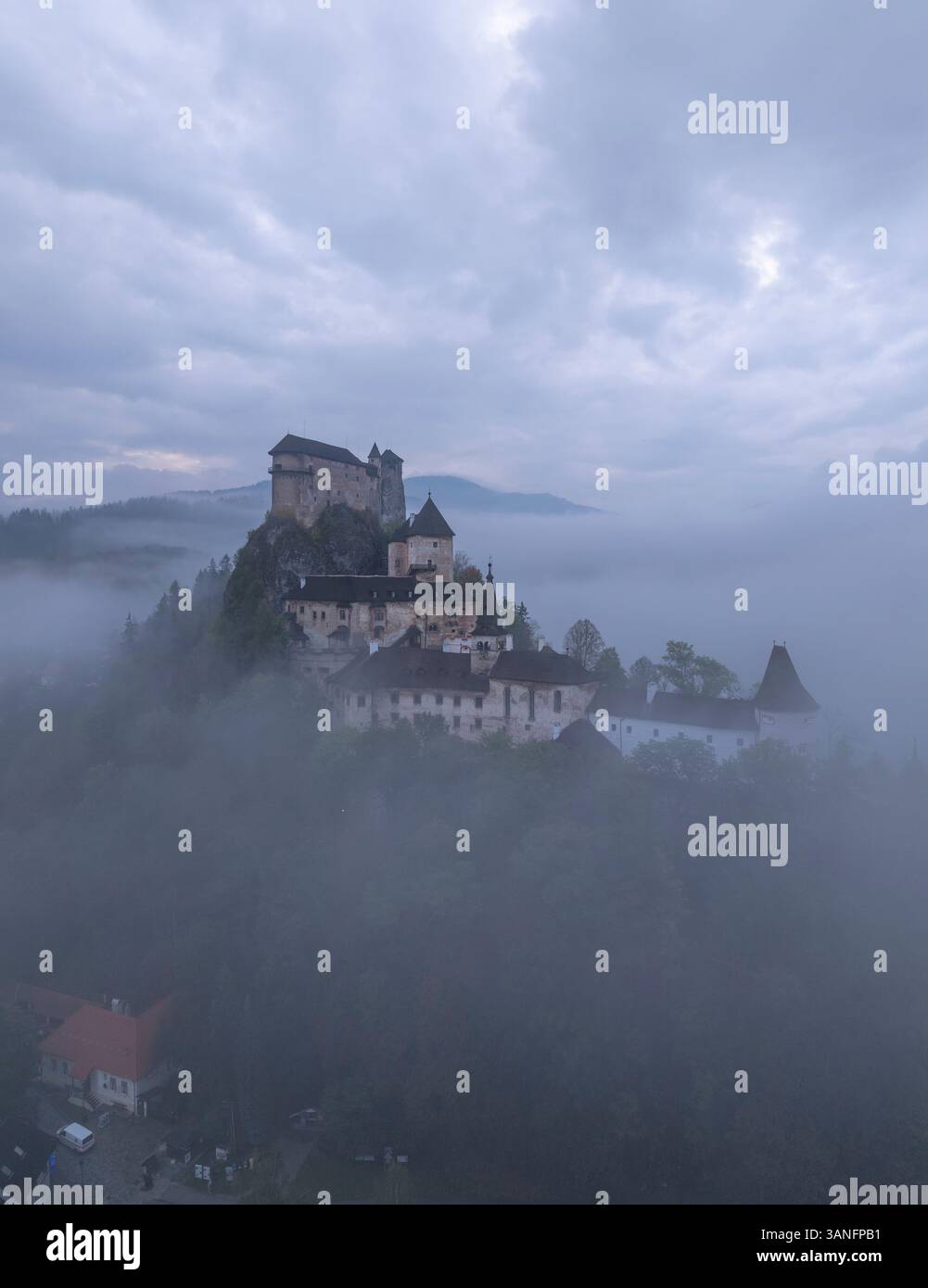 Aus der Vogelperspektive auf die Burg Orava im Nebel bei Sonnenaufgang, Oravsky Podzamok, Zilina, Slowakei. Stockfoto