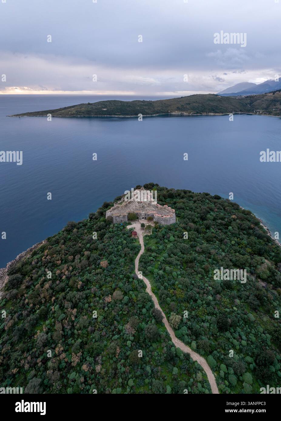 Blick aus der Vogelperspektive auf die historische Burg von Porto Palermo am ruhigen Mittelmeer mit zerklüfteter Küste und malerischen Bergen, Porto Palermo, Stockfoto