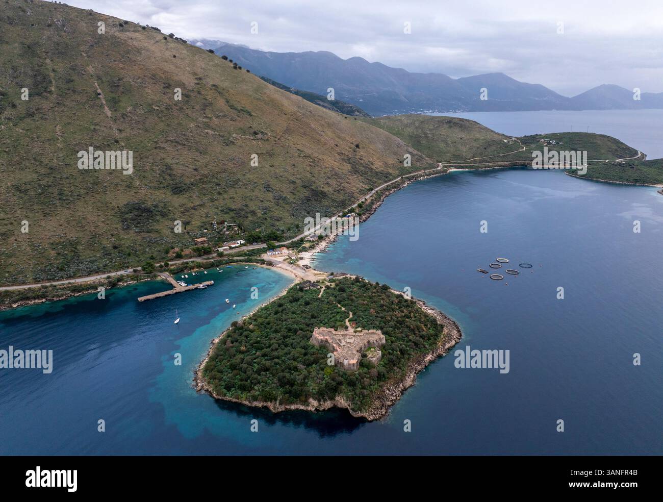 Blick aus der Vogelperspektive auf das malerische Schloss von Porto Palermo, umgeben von ruhigem blauem Wasser und üppigem Grün, Porto Palermo, Vlore, Albanien. Stockfoto