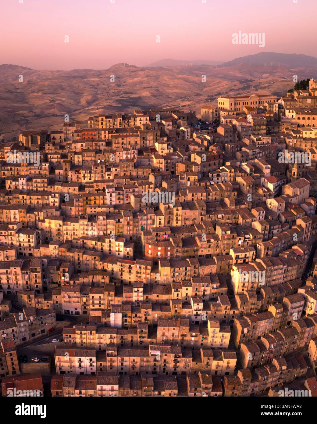 Blick aus der Vogelperspektive auf die malerische Altstadt mit bezaubernden Häusern und einer Bergkulisse bei Sonnenuntergang, Gangi, Italien. Stockfoto