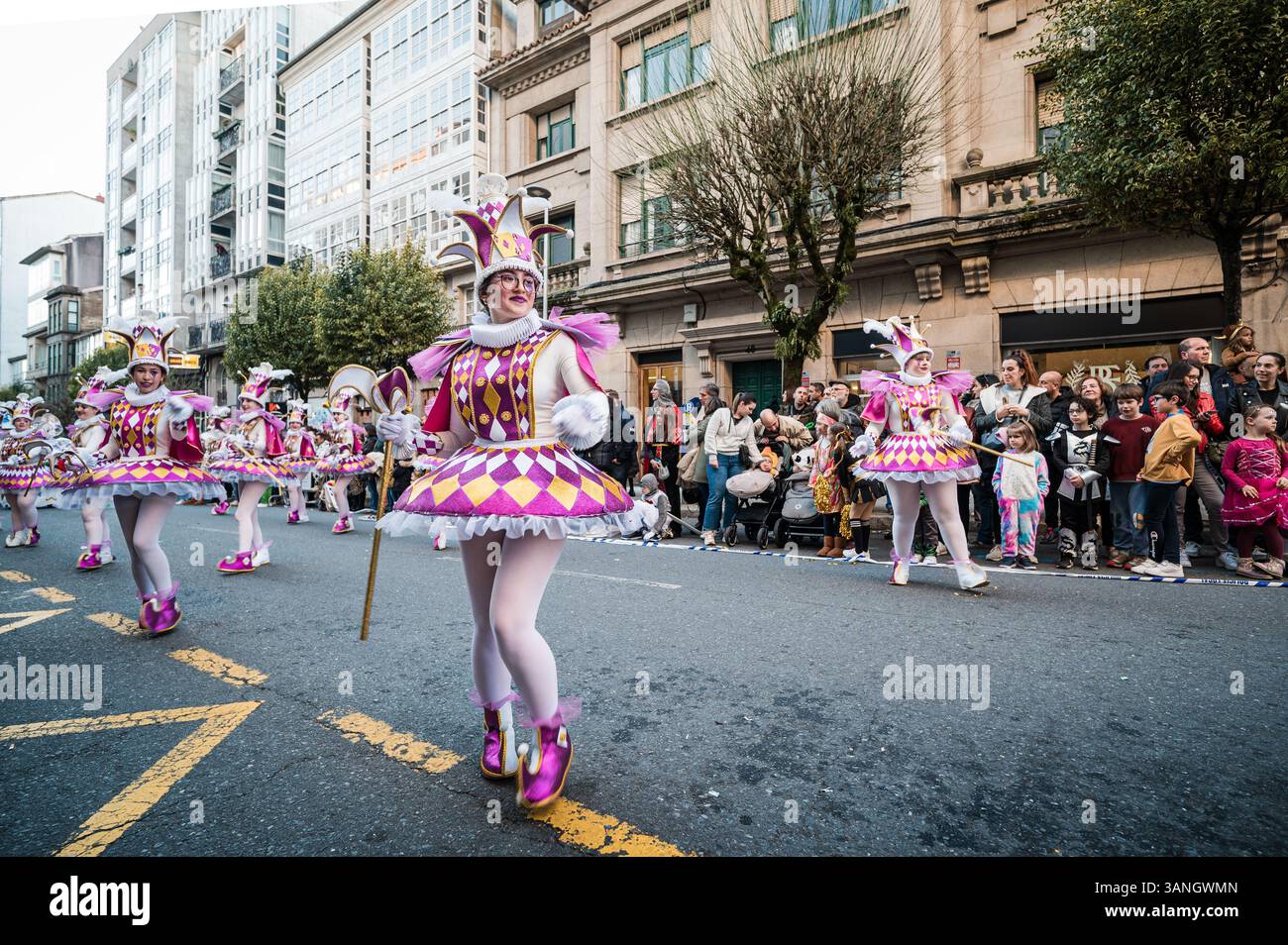 Fröhliche Frauen tanzen in Harlekin-Kostümen während der Karnevalsparade in santiago de compostela Stockfoto
