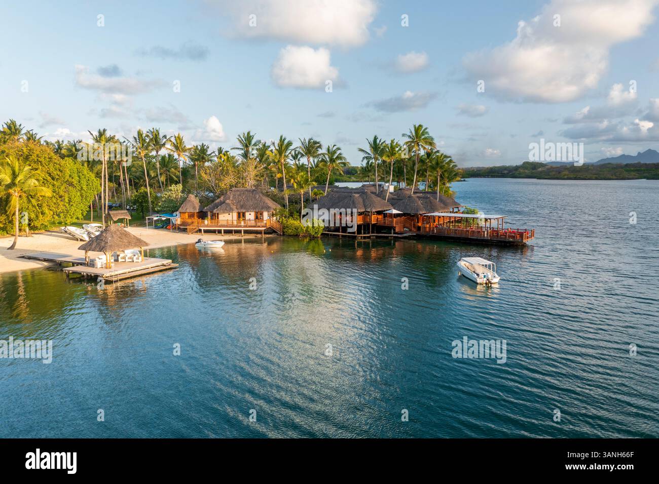 Flacq, Mauritius - 28. September 2022: Blick aus der Vogelperspektive auf den Bungalow am Strand eines Luxusresorts mit einem kleinen Boot, das sich der Küste, Poste d. Nähert Stockfoto