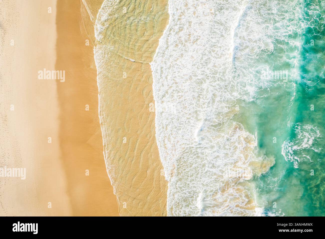 Blick aus der Vogelperspektive auf Sunshine Beach mit Meereswellen, die entlang der Alexandra Bay, Queensland, Australien, auf den Sand stürzen. Stockfoto