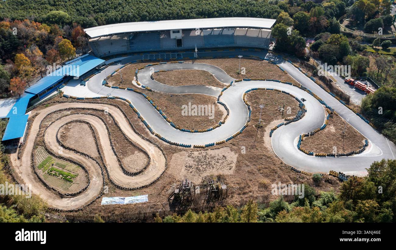 Blick aus der Vogelperspektive auf eine malerische Rennstrecke, umgeben von üppigem Grün und Wald, Songjiang District, Volksrepublik China. Stockfoto