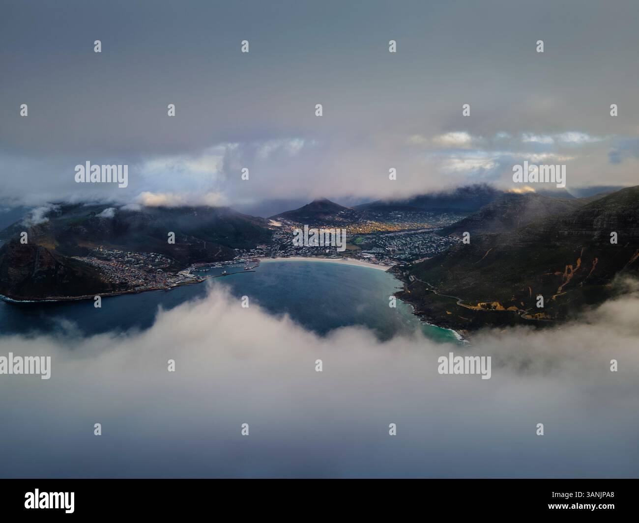 Aus der Vogelperspektive auf den nebeligen See und die majestätischen Berge bei Sonnenaufgang, Hout Bay, Kapstadt, Südafrika. Stockfoto