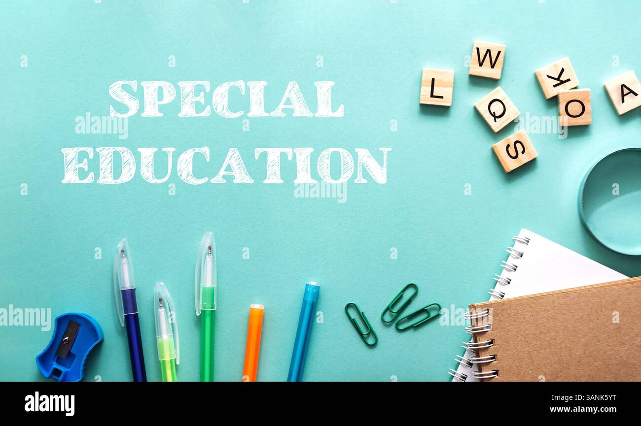 Blauer Hintergrund mit einem Haufen Schulmaterial und den Worten Sonderpädagogik. Das Zubehör umfasst eine Schere, einen Bleistift, einen Stift und ein Paar Stockfoto