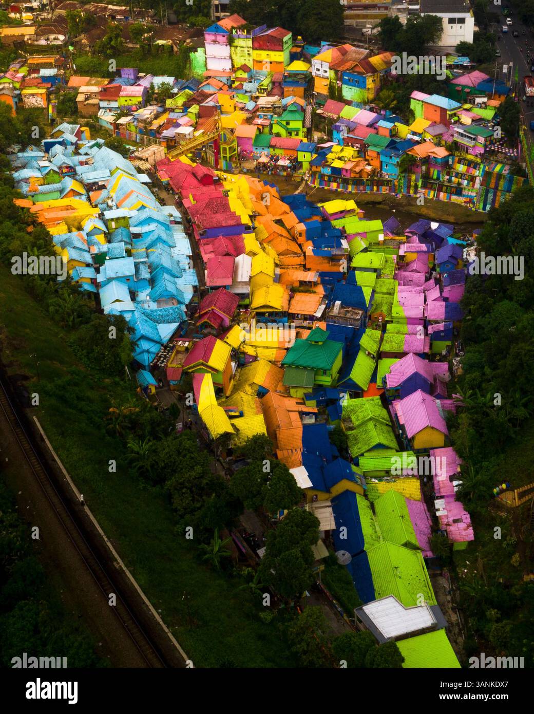 Blick aus der Vogelperspektive auf farbenfrohe Häuser und pulsierende Dächer in einem malerischen Viertel, Blimbing, Ost-Java, Indonesien. Stockfoto