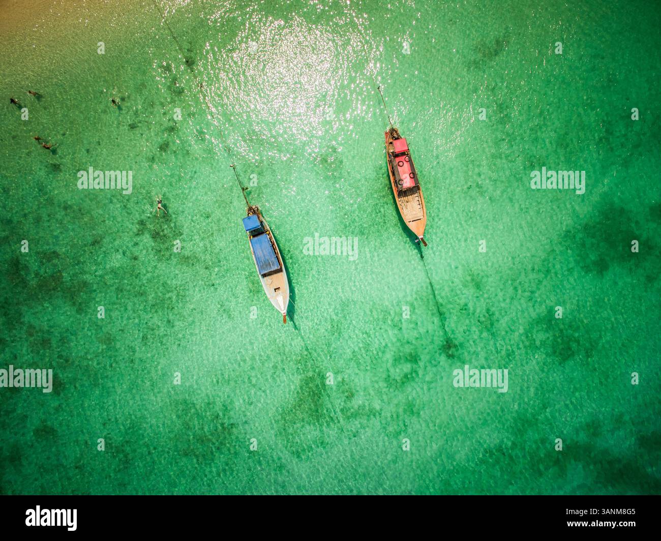 Blick aus der Vogelperspektive auf zwei traditionelle Langboot-Boote, die im paradiesischen Meer des Chao Mai National Park in Thailand verankert sind. Stockfoto