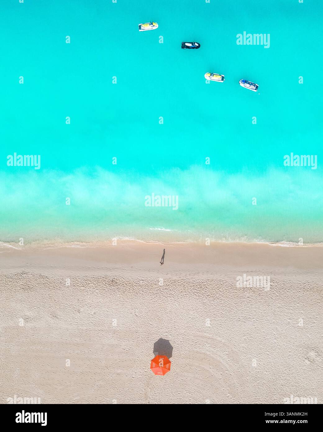 Aus der Vogelperspektive einer Person, die entlang der Küste am Eagle Beach in Aruba spaziert. Stockfoto