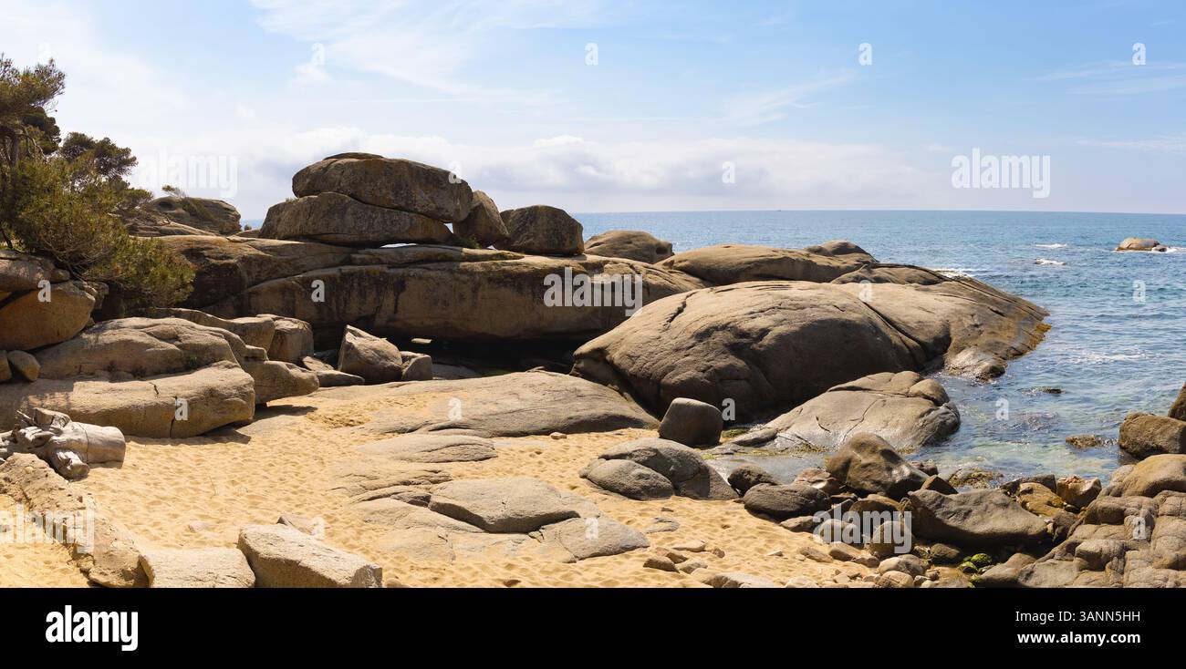 Panoramablick auf Punta Rocas Planes, Costa Brava, mit seinen einzigartigen glatten Felsen an einer kleinen Sandbucht und dem blauen Mittelmeer. Stockfoto