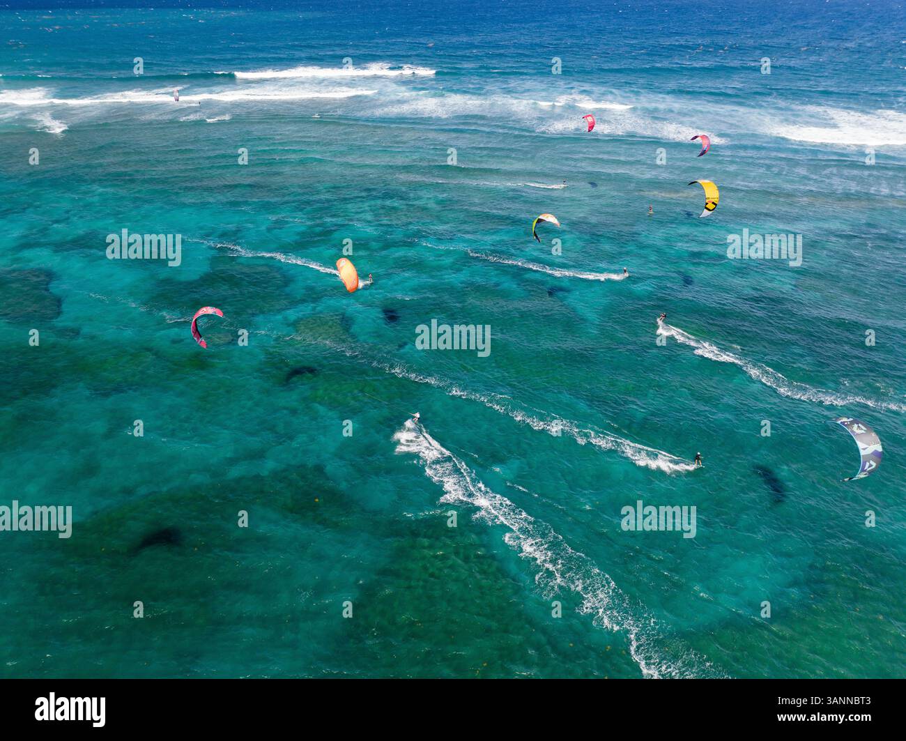 Aus der Vogelperspektive von Kitesurfern, die auf den Wellen in einem wunderschönen Ozean reiten, Sosua, Dominikanische Republik. Stockfoto