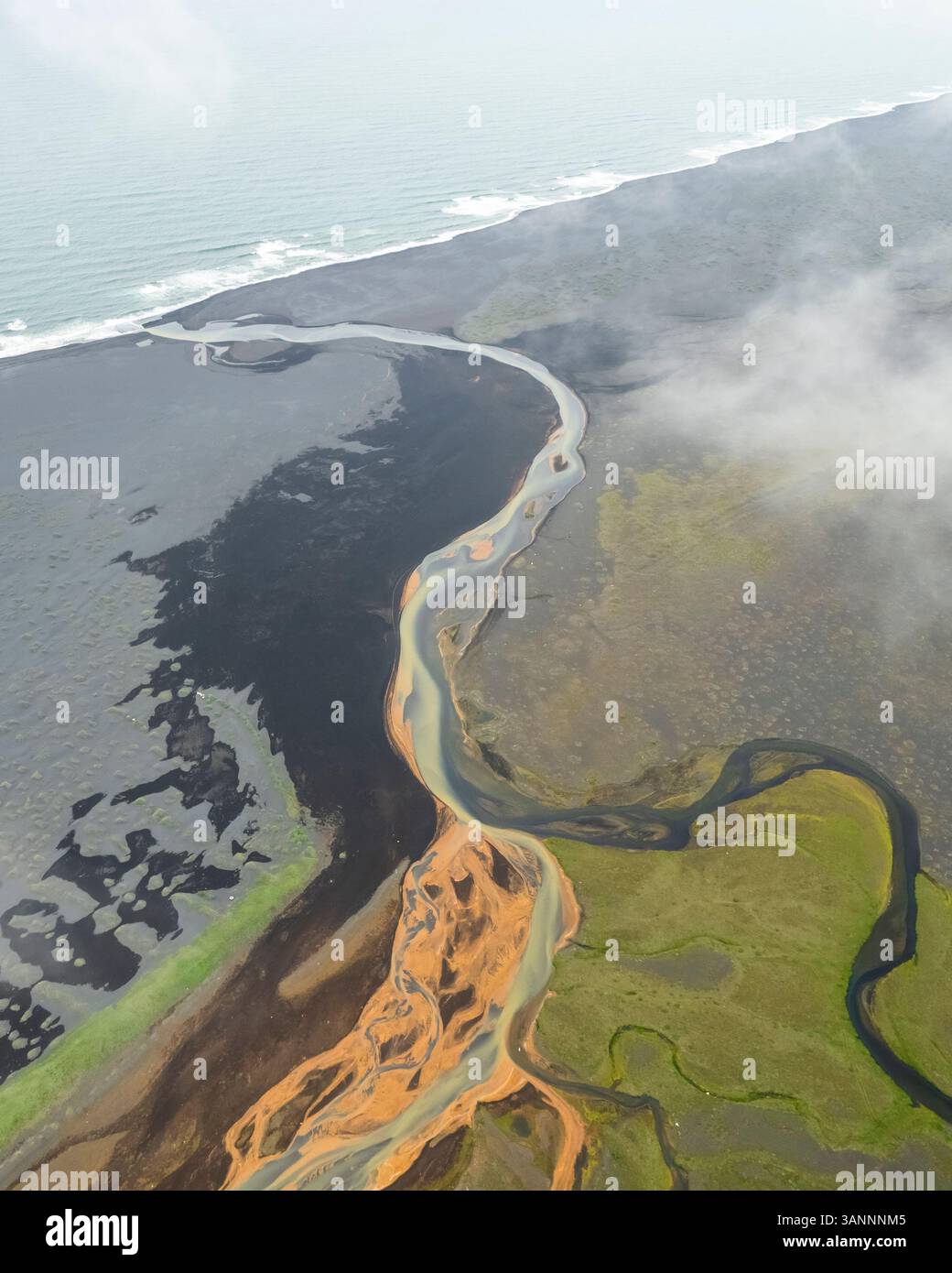 Aus der Vogelperspektive eines Flusses, der in Richtung Ozean fließt, Island. Stockfoto