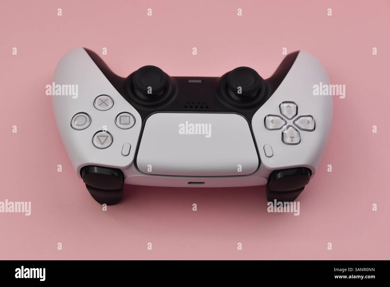 Weißer Joystick auf rosafarbenem Hintergrund. Das Konzept der Online-Spiele. Stockfoto