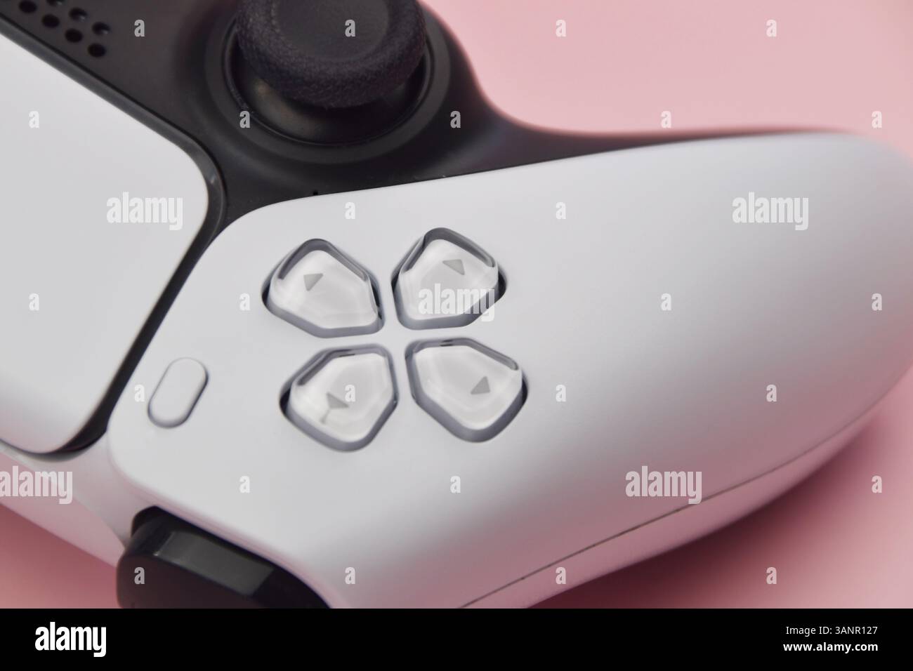 Weißer Joystick auf rosafarbenem Hintergrund. Das Konzept der Online-Spiele. Stockfoto