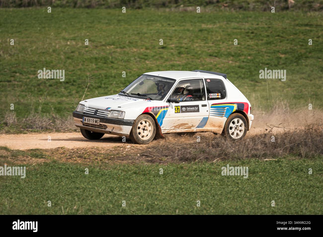 Madrid, Spanien; 15.02.2025: Der legendäre Peugeot 205 GTI brüllt während einer Rallye-Feier auf einem Feldweg, wobei ein Rad von der Rennstrecke abdriftet und RAW erfasst Stockfoto