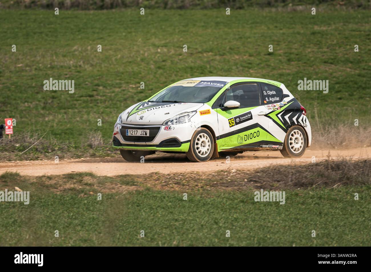 Madrid, Spanien; 15.02.2025: Peugeot 208 beschleunigt auf einer Schotterpiste und hebt Staub auf, dessen dynamische Bewegung und Staubwolke die Rohintensität von ral widerspiegeln Stockfoto