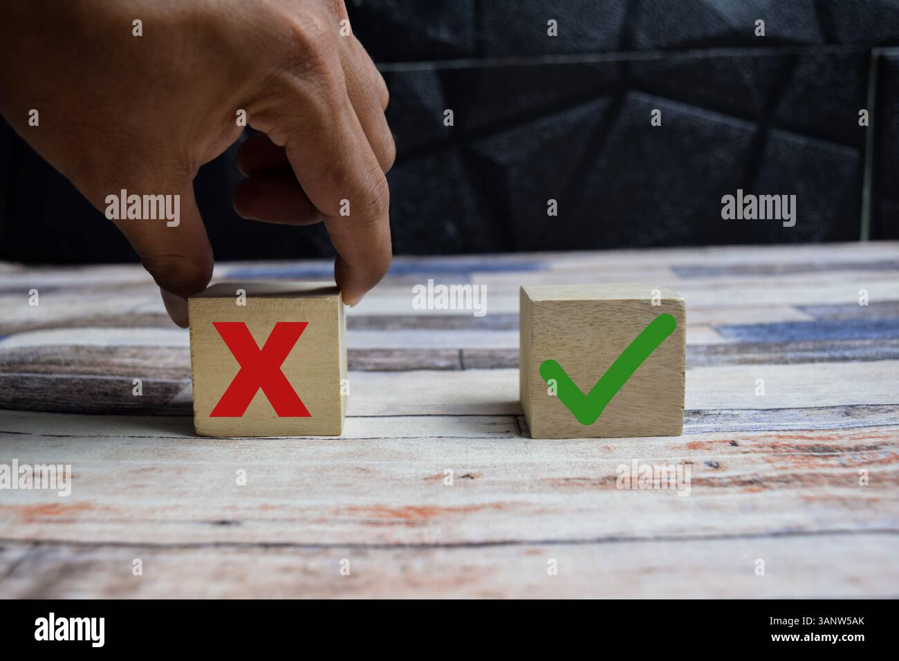 Auswahlsymbol für Konzeptwort Ja oder Nein. Handarbeit zwischen zwei Würfeln mit Ja und Nein Symbol auf Holzblöcken auf einem Holztisch Stockfoto